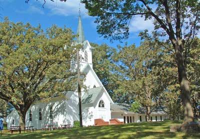A photo of the Nora UU church in the summer.